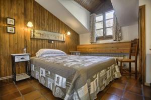 贝纳斯克San Marsial Benasque Apart Hotel的卧室配有一张床铺,位于带木墙的房间内