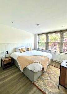莱瑟姆-圣安妮Mode Apartments St Annes的一间卧室设有一张大床和两个窗户。