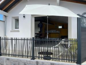 安格雷Charmant Studio pouvant accueillir 4 personnes的房屋前的白色遮阳伞