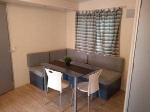 阿梅利亚Mobile home Comfort Ameglia - including airco - Camping River- 327的小型用餐室配有桌椅