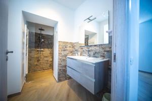 里诺迪莱吉诺Around Lago Maggiore rooms的一间带水槽和石墙的浴室