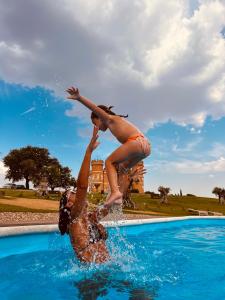 托罗Castillo de Monte la Reina Posada Real & Bodega的两个人跳进游泳池