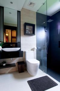 长滩岛长滩套房酒店的浴室配有卫生间、盥洗盆和淋浴。
