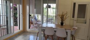 科斯塔巴伦娜Costa Ballena!!! House on Mediterranean Coast with pool and golf!!! Dúplex!!!的一间带桌子和白色椅子的用餐室