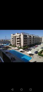 Al Ḩammāmصيف في جراند هيلز الساحل الشمالي的大型公寓大楼,设有游泳池和建筑