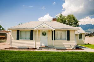奥勒姆Cozy Cottage Retreat in the Heart of Utah Valley的白色的房子,有门和草坪