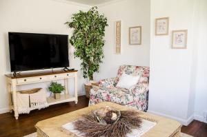 奥勒姆Cozy Cottage Retreat in the Heart of Utah Valley的客厅配有电视、椅子和桌子