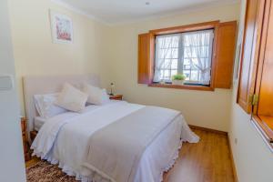 雷卡杜巴里奥Araújo 111 - Traditional House的卧室配有白色的床和窗户。