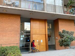 圣地亚哥Jardines的一个人在建筑物前骑着自行车