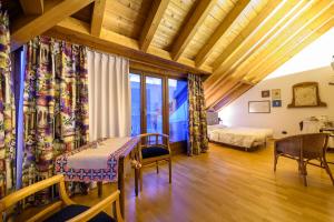 蒂拉诺Bernina Express Eco Rooms&Breakfast的配有一张床和一张桌子及椅子的房间