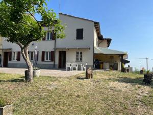 Montalto PaveseIL NIDO DELLA POIANA CASA VACANZE e B & B的坐在房子前面的猫