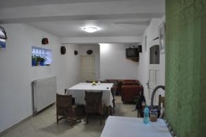 锡纳亚维拉皮蒂酒店的一间配备有白色桌子和沙发的用餐室