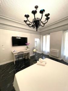 阿拉西奥Casa Balzola - Suite Adamas的一间卧室配有一张床、一张书桌和一个吊灯。