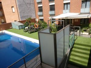 阿尔卡拉德荷那利斯胡安一世公寓酒店的阳台设有游泳池和遮阳伞。