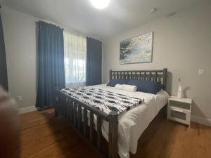 Okanagan FallsKaleden Guest Suite的一间卧室配有床和蓝色窗帘的窗户