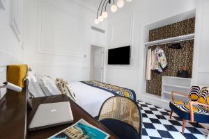 索伦托YourHome - Maison Iovino Luxury Rooms的一间卧室配有一张床和一张带笔记本电脑的书桌