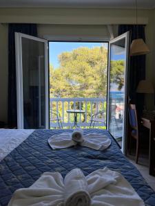 科斯镇特奥多海滩公寓酒店的一间卧室配有带毛巾的床和阳台