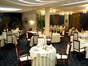 布尔加斯美丽华酒店 的一间设有白色桌椅的用餐室