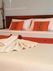 功孟海滩假日旅馆的两张带白色床单和橙色枕头的床