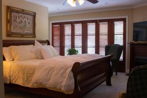 滨湖尼亚加拉Upper Canada Coach House的一间卧室配有一张带白色床单和窗户的床。