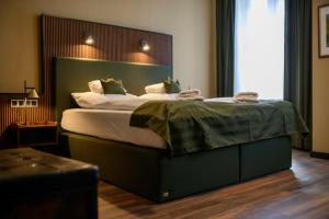 齐陶Stadthotel König Albert的一间卧室配有一张大床和绿色床头板
