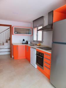 雷乌斯Chalet amplio con Jardín y zona barbacoa.的厨房配有橙色和白色的橱柜和电器