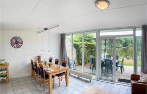Vlagtwedde3 Bedroom Cozy Home In Vlagtwedde的一间带桌椅的用餐室和一个庭院
