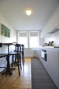 布鲁塞尔Appartement Chic的厨房配有白色橱柜和桌椅
