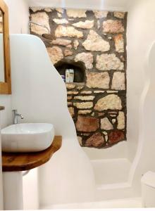 阿波罗尼亚Villa DORIANA IN PELEKOUDA的一间带水槽和石制壁炉的浴室