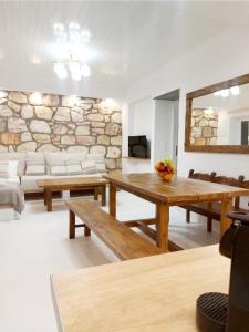 阿波罗尼亚Villa DORIANA IN PELEKOUDA的客厅设有木桌和石墙