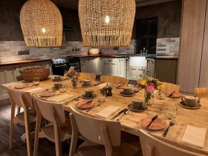 巴纳德城堡Runa Farm的厨房里配有一张大木桌、椅子和花卉桌子