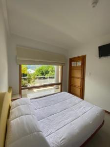 MéridaCasa Tramontana的卧室设有一张白色大床和一扇窗户。