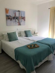 金塔湖Quinta do Lago Golf, Sea & Sun的一间卧室配有两张床,并备有托盘