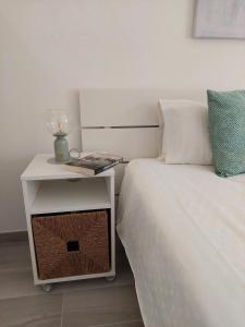 金塔湖Quinta do Lago Golf, Sea & Sun的一张带床头柜的床,旁边是一张带边桌的白色床