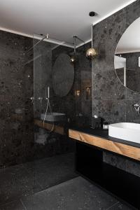 卡瓦莱塞Alpuris - Your Boutique Suite - Hotel B&B的一间带水槽和玻璃淋浴的浴室