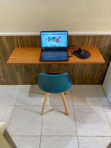 福塔莱萨Refúgio Pousada Fortaleza的一张桌子,上面有笔记本电脑,鼠标和椅子