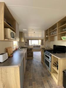 海斯廷斯Modern & Homley 3BR Caravan的厨房配有木制橱柜和炉灶烤箱。