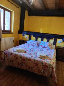 霍约斯德尔埃斯皮诺CASA RURAL EL TOLEO的一间卧室配有一张带花卉床罩的床