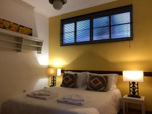 丰沙尔Casa do Poço Funchal的一间卧室配有一张带两盏灯的床和一扇窗户。