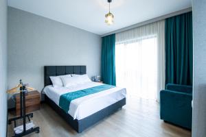 卡兹贝吉Hotel GENI Kazbegi的一间卧室配有一张床和一张蓝色椅子