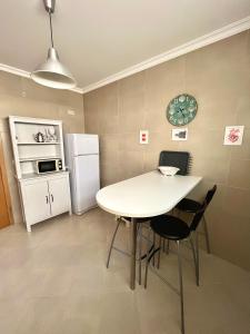塞辛布拉Arte de Marinheiro的厨房配有桌椅和冰箱。