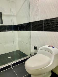 卡利Hotel Avei Suites的浴室配有白色卫生间和淋浴。