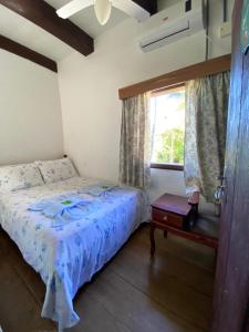 波梅罗迪Pousada Casa Wachholz - Rota do Enxaimel的一间卧室设有一张床和一个窗口