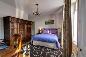 瓦讷Maison de la Garenne & Spa的一间卧室配有一张床、一张桌子和一个吊灯。