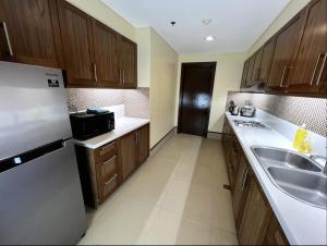 莫龙Anvaya Cove Short Term Rental Condos的厨房配有木制橱柜、水槽和冰箱。