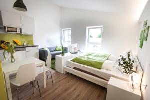 格拉茨一室公寓+公寓式酒店的一间白色的小房间,配有床和厨房