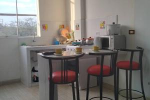 齐克拉约Departamento - Los Mitos del Parque M2的厨房配有2张吧台凳和微波炉
