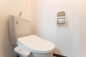 横滨Yokohama Sakuragicho Town Hotel的浴室设有白色卫生间和遥控器