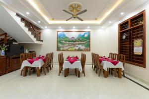 宁平Tan Dinh Farmstay的一间带桌椅的用餐室和一幅画