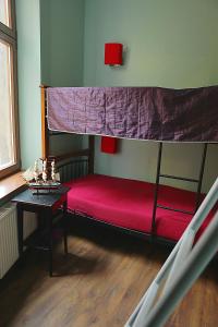 托伦天使旅馆 的一间卧室配有一张带红色床罩的双层床